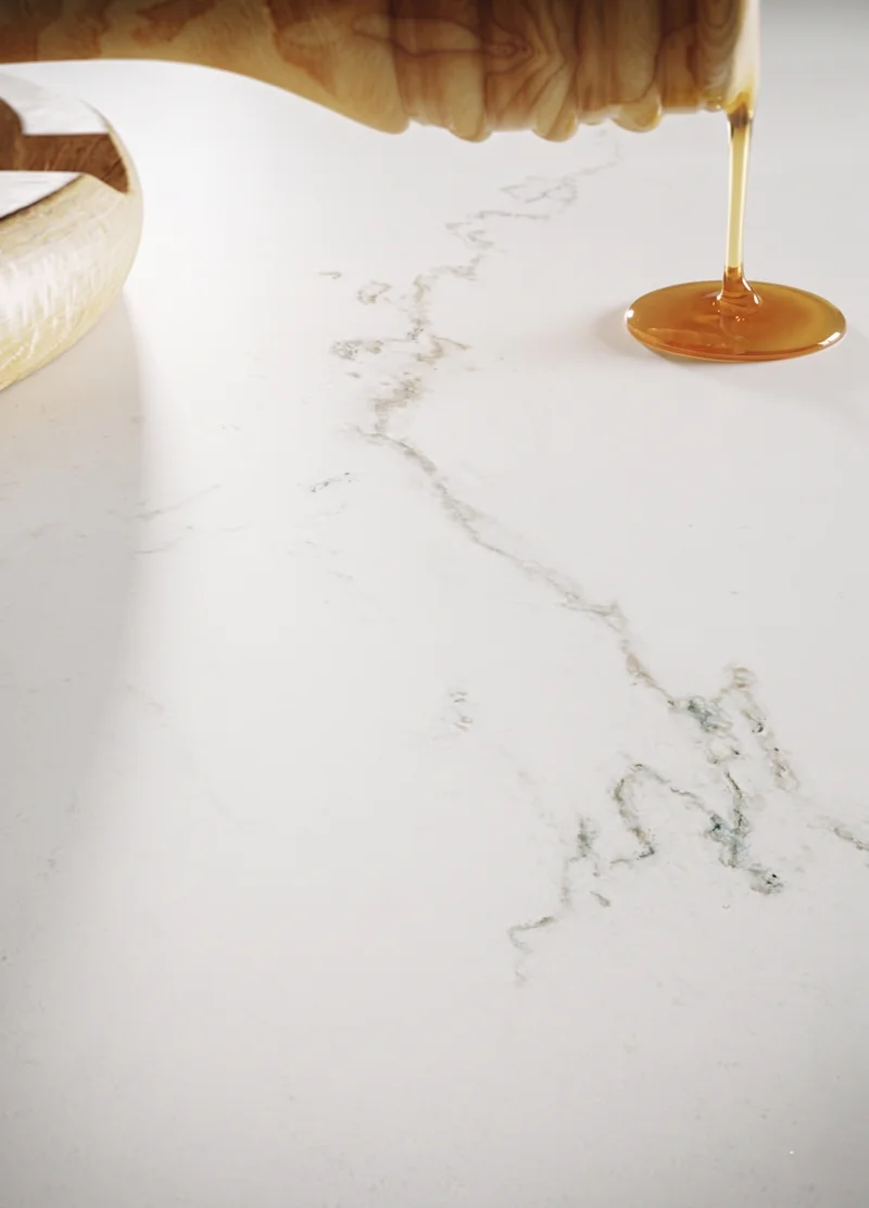 Filet de miel versé sur un quartz adouci mat au veinage discret : aucune brillance, la matière absorbe la lumière